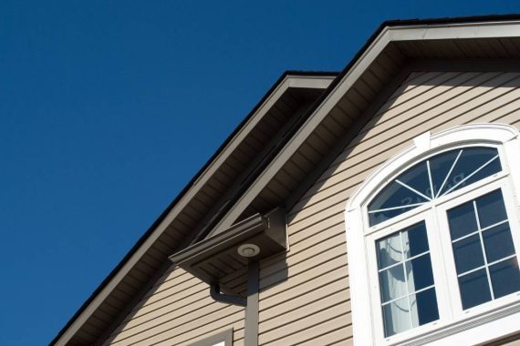 A close-up view of the upper level of a house with windows and siding