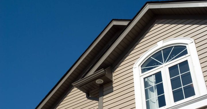 A close-up view of the upper level of a house with windows and siding