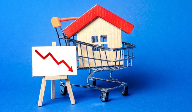 A miniature house in a shopping cart with a downward trend(to show mortgage rates forecast) on a blue background.