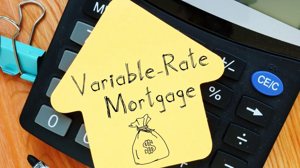 variable mortgage written on a yellow house cutout with a calculator on the background.