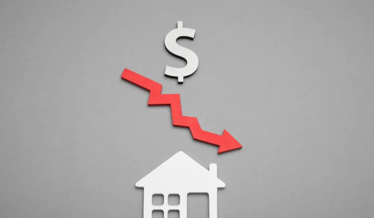 dollar sign with a red arrow point down placed above a house cutout on a grey background